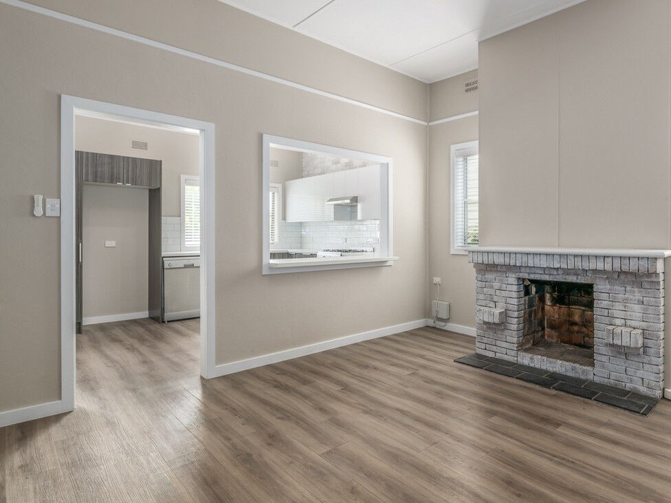 Renovated living room with kitchen servery and original fireplace